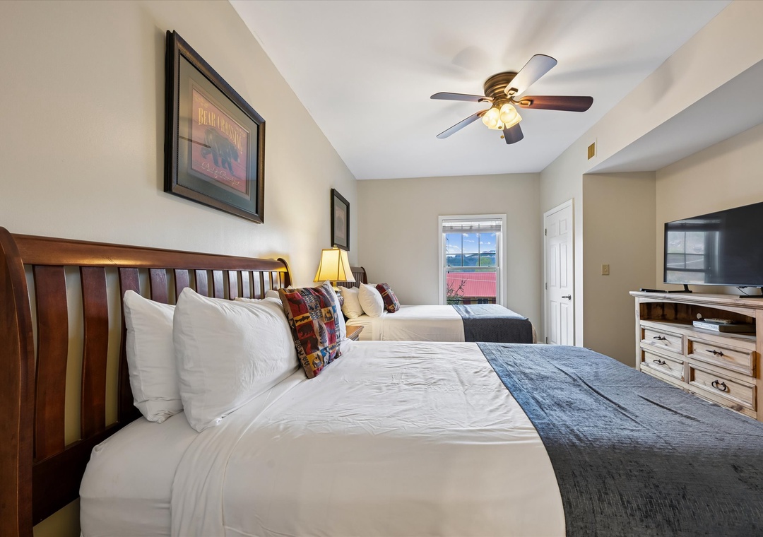 Relax in your comfortable bedroom featuring two plush beds with crisp linens, rustic wood furnishings, and modern amenities for a perfect mountain getaway.