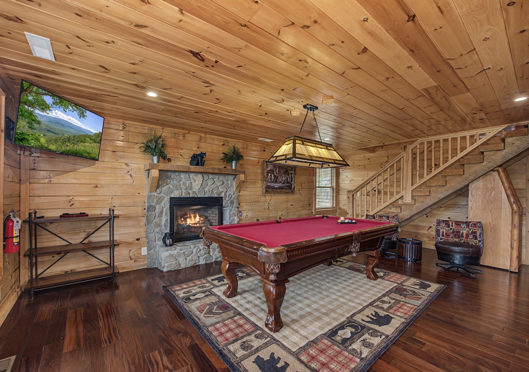 Your private game room awaits with a full-size billiard table, cozy stone fireplace, and big-screen TV—perfect for unwinding after a day of mountain adventures.