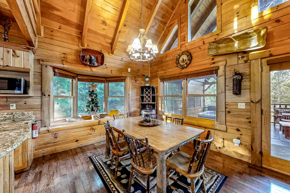 Gather around this rustic dining table where warm wood beams frame your mountain retreat meals and memorable conversations with loved ones.