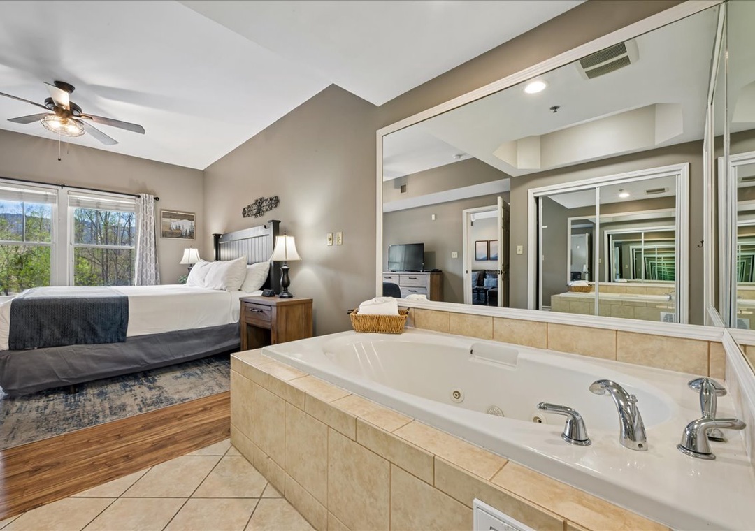 Unwind in your spacious bedroom featuring a luxurious jetted tub, perfect for romantic evenings with stunning views of the surrounding landscape.