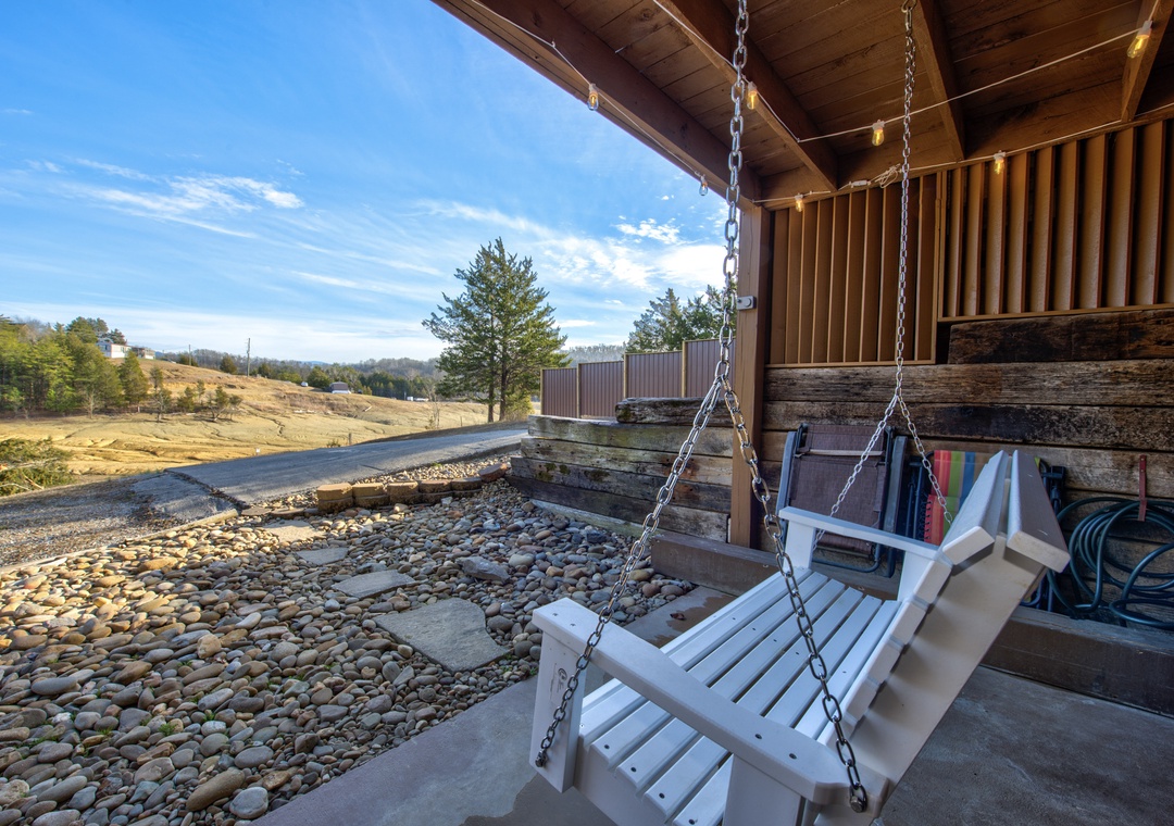 Unwind on your private swing while soaking in stunning countryside views from this charming covered porch.