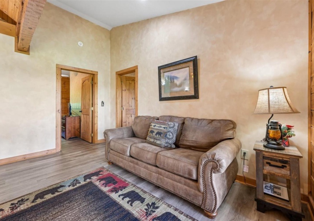 Unwind in your cozy living space with warm wood accents, soft lighting, and comfortable seating—perfect for relaxing after a day of mountain adventures.