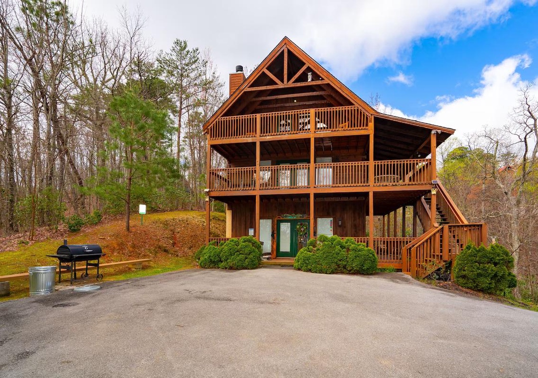 A stunning three-story log cabin retreat nestled among trees, featuring multiple balconies and BBQ facilities for the perfect mountain getaway.