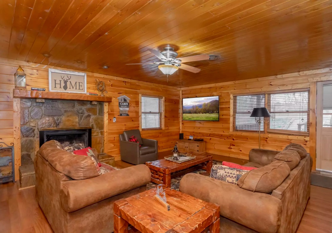 Sink into plush leather sofas by the stone fireplace while mountain views fill the flatscreen—your perfect cabin retreat awaits.