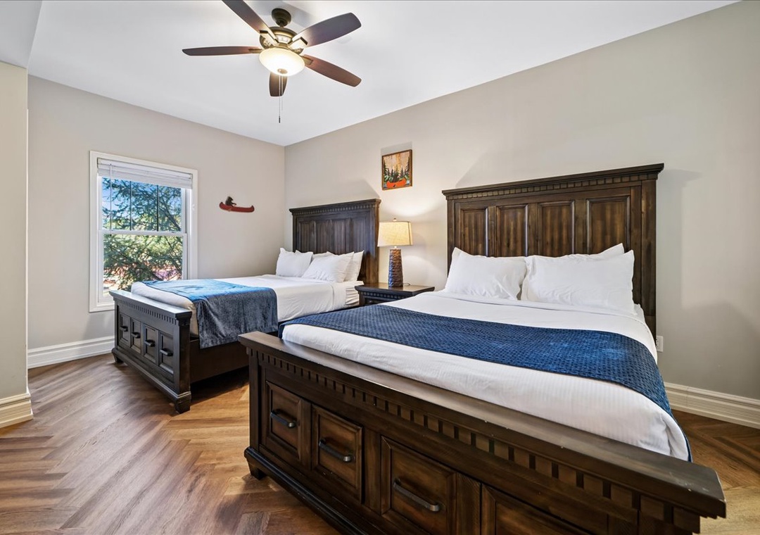Rest peacefully in your spacious bedroom with handcrafted wooden beds, crisp linens, and gentle ceiling fan creating perfect comfort.