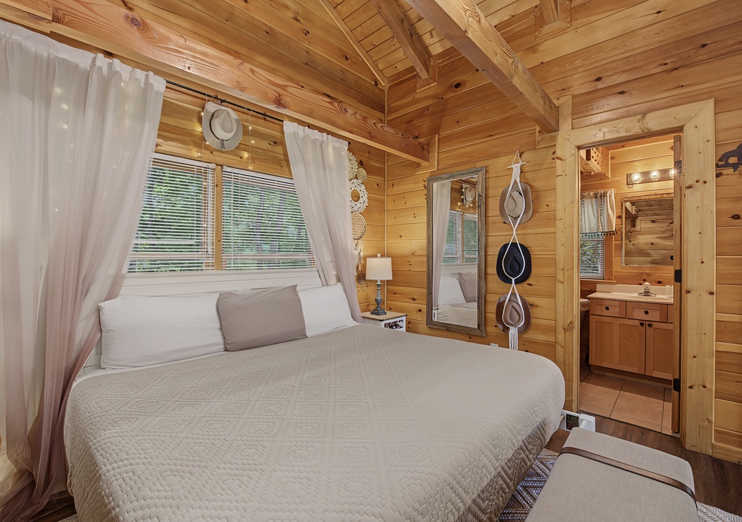 Drift into restful sleep beneath soaring pine ceilings in this inviting bedroom, where soft linens and gentle natural light create your perfect mountain retreat.