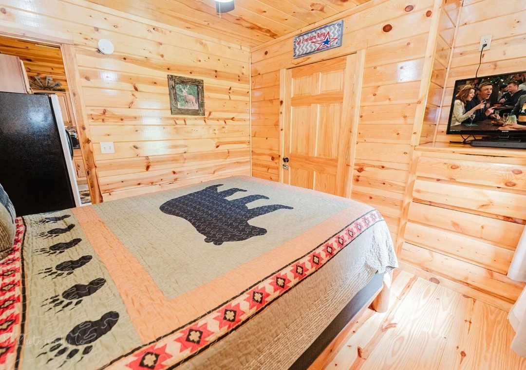 Your cozy bedroom features warm wood walls and rustic decor that creates a welcoming retreat after your mountain adventures.