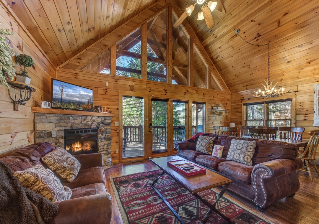 Unwind in your cozy mountain cabin living room with crackling fireplace, leather furniture, and rustic charm throughout.