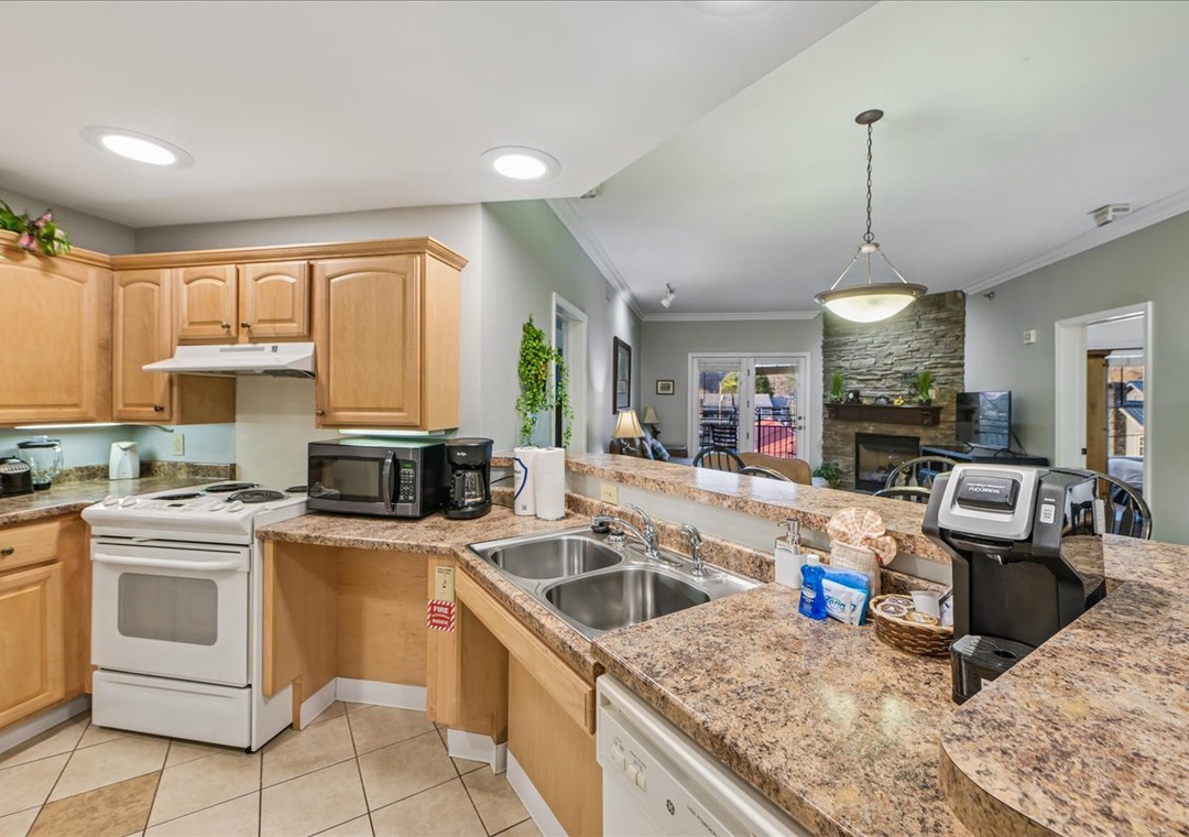 Your fully-equipped kitchen features granite countertops, warm wood cabinetry, and modern appliances, perfect for preparing memorable meals during your stay.