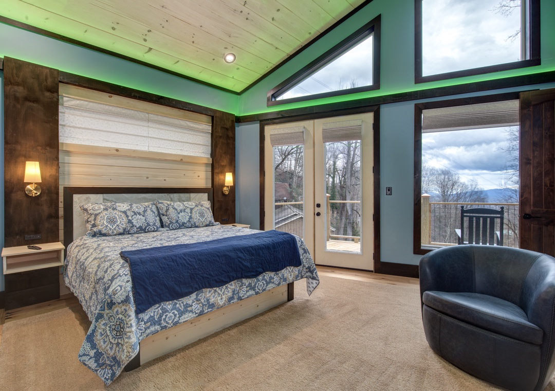 Unwind in your stylish bedroom featuring vibrant green accents, rustic wood beams, and floor-to-ceiling windows that frame stunning mountain views.