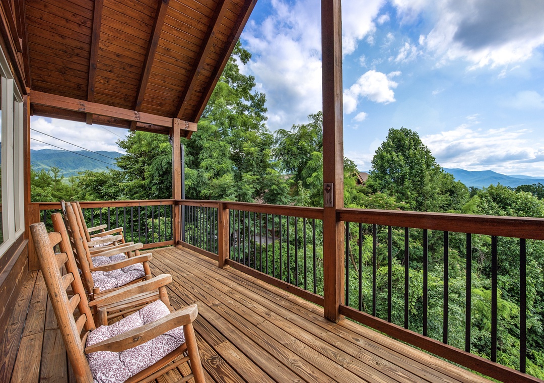 Sink into plush rocking chairs on your covered deck and soak in sweeping mountain views framed by lush forest canopy and vibrant blue skies.
