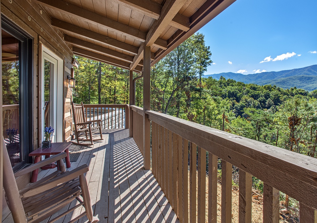 Breathe in the mountain air from your private deck, where rocking chairs invite you to sip morning coffee while taking in sweeping mountain and forest views. This is your peaceful sanctuary above it all.