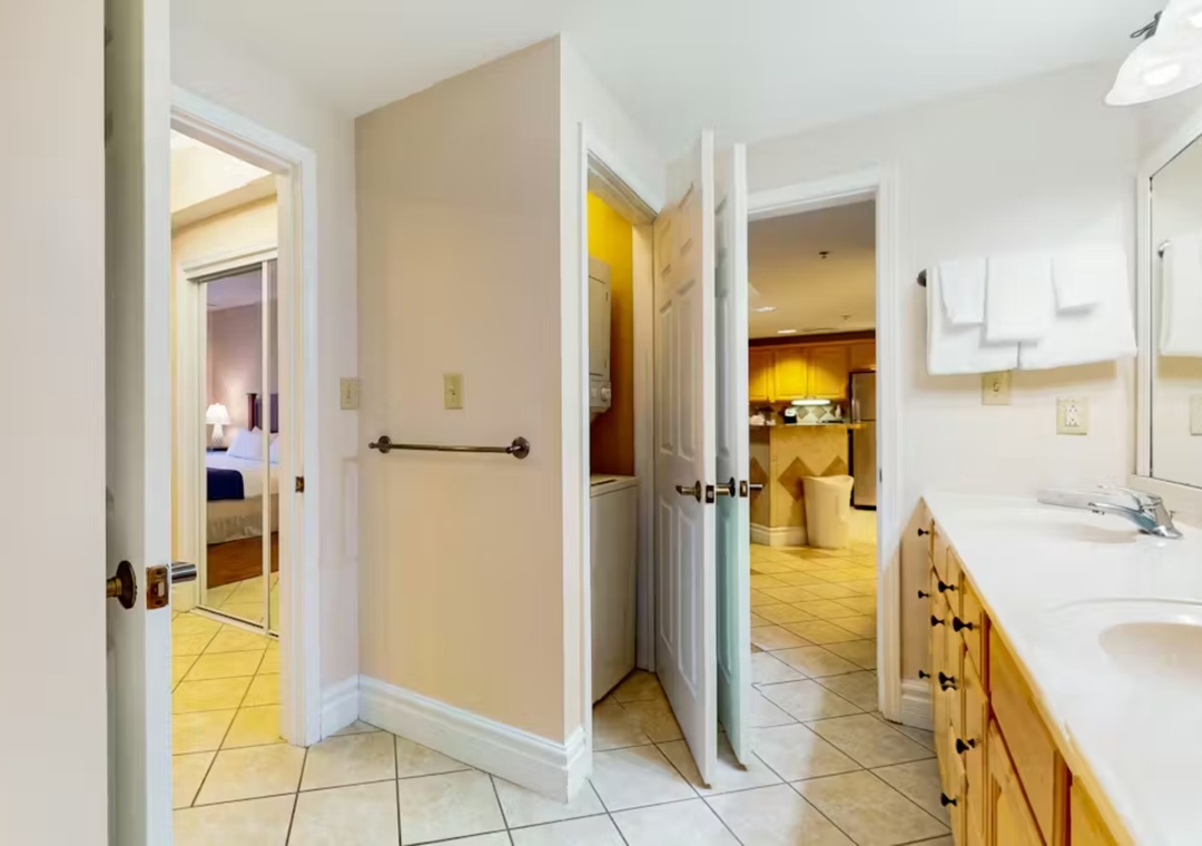 Your spacious bathroom features dual vanities with ample storage, fluffy towels, and connects seamlessly to your bedroom and kitchen.