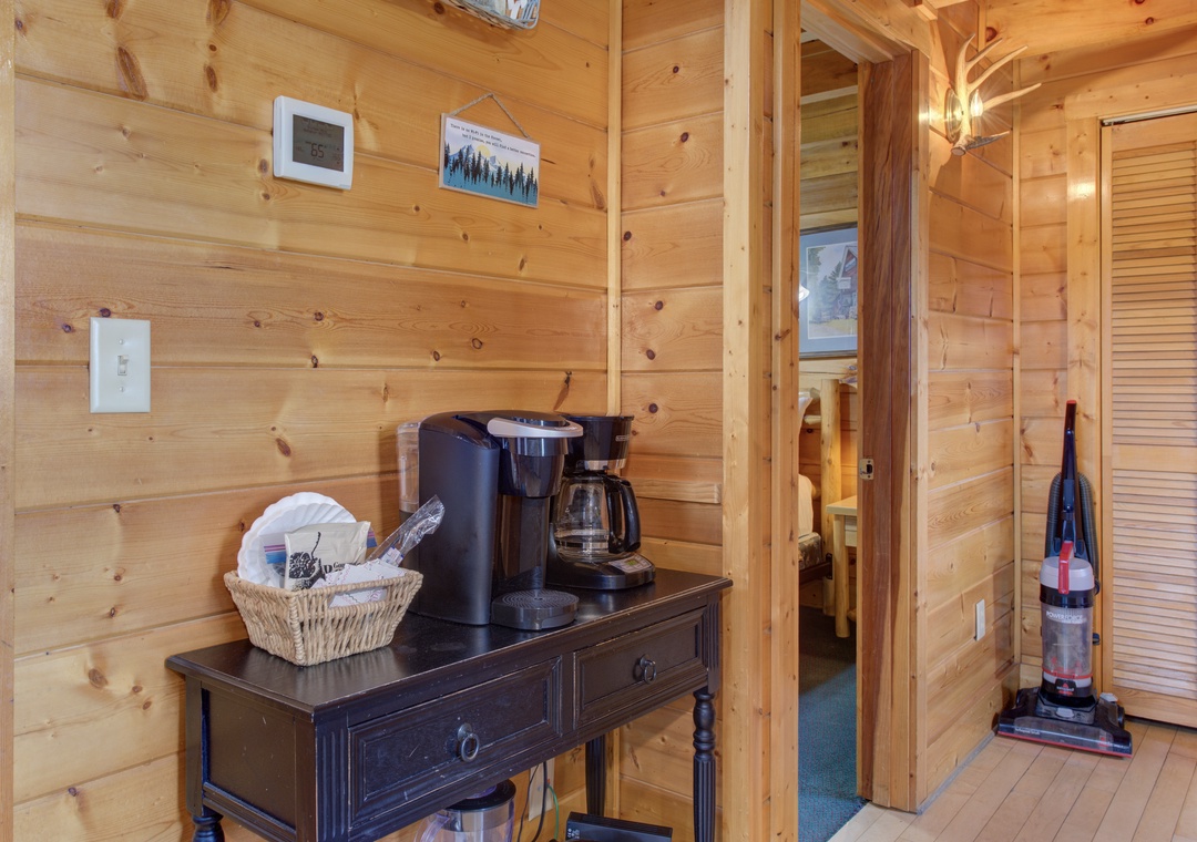 Warm wood surrounds your coffee station, perfect for brewing your morning cup in this cozy cabin retreat.