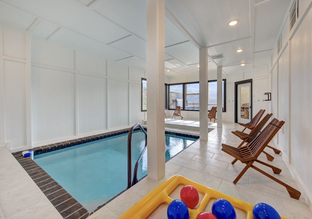 Dive into your private indoor pool paradise, where wooden lounge chairs await your relaxation after a refreshing swim in crystal-clear waters.