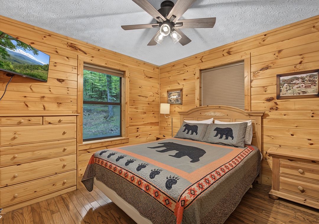 Cozy up in your rustic bedroom with knotty pine walls and forest views—perfect for a peaceful night's sleep after a day of exploring the mountains.
