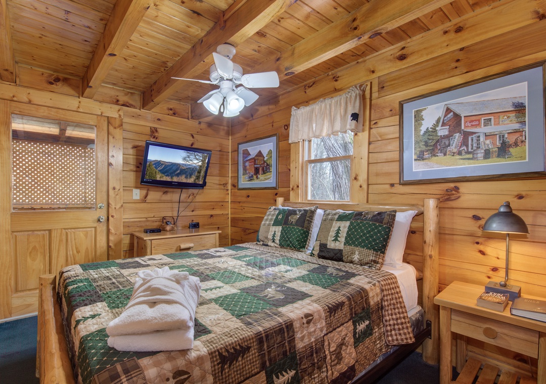 Unwind in your cozy log cabin bedroom with rustic charm, soft quilted bedding, and peaceful forest views from your window.