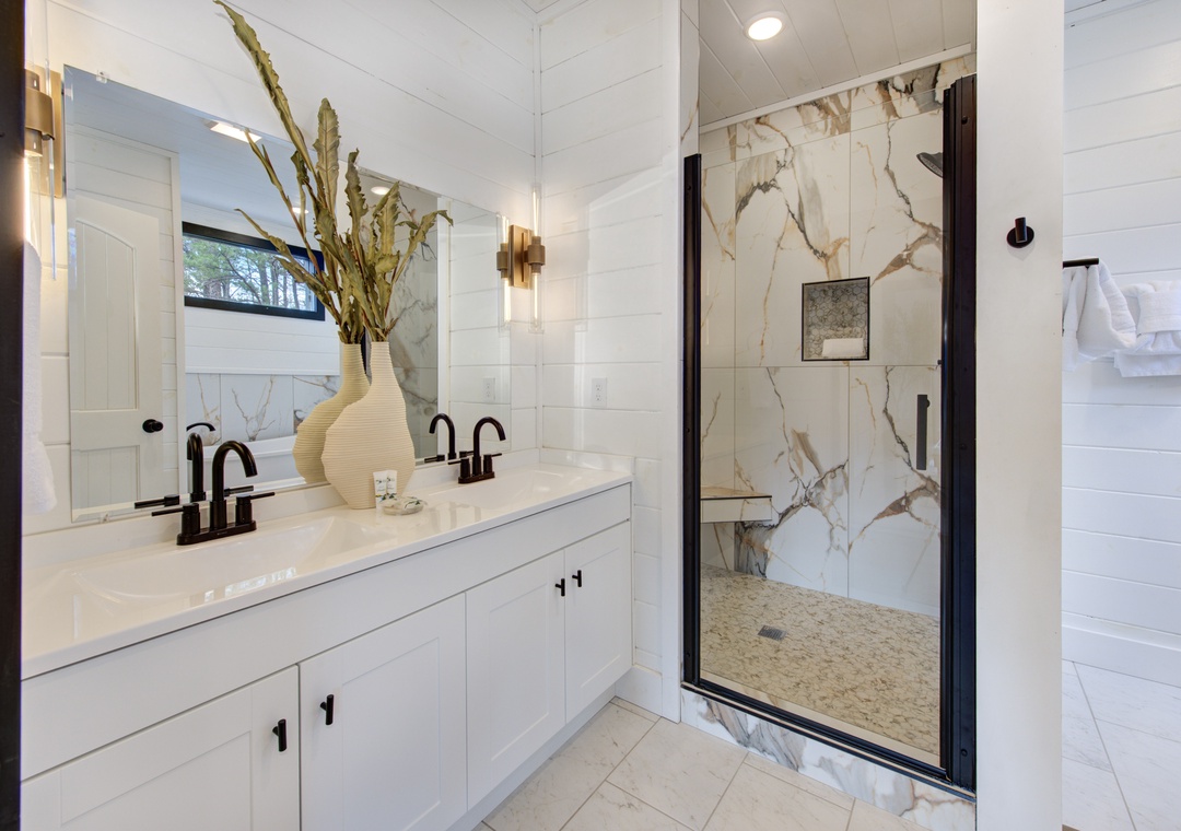 Unwind in your spa-like bathroom featuring a stunning marble shower, elegant dual vanity, and luxurious finishes that make every moment feel indulgent.