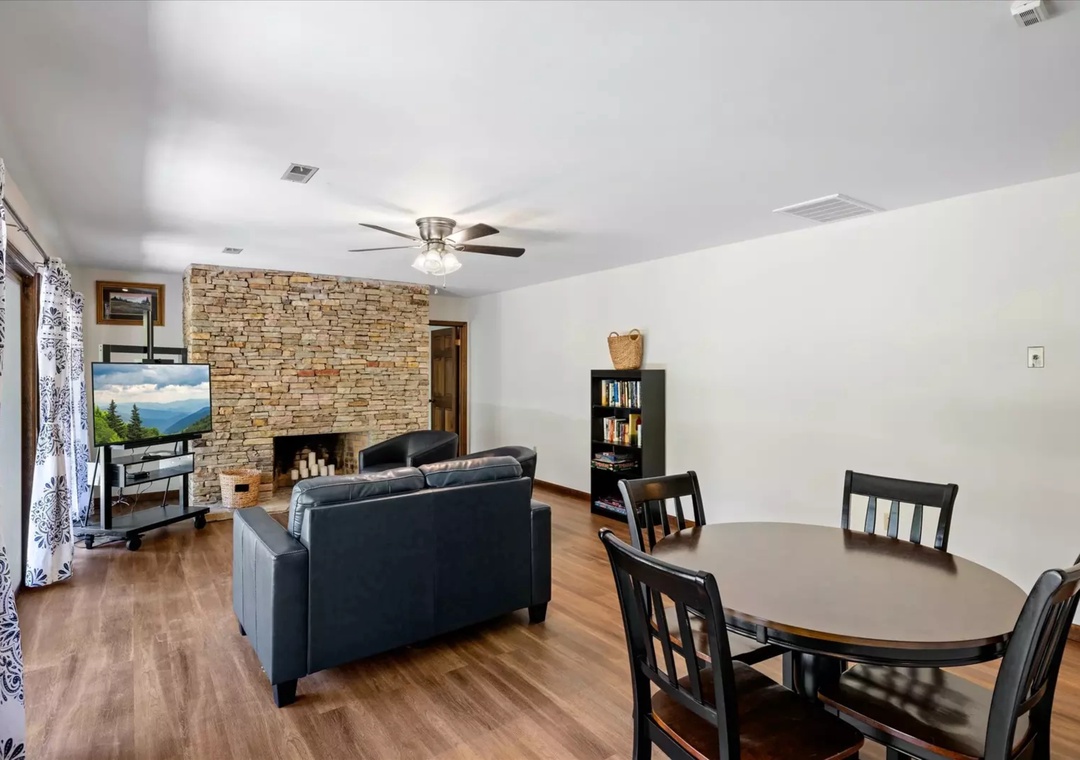 Unwind in your spacious living area with cozy seating, crackling fireplace, and entertainment center for perfect evening relaxation.