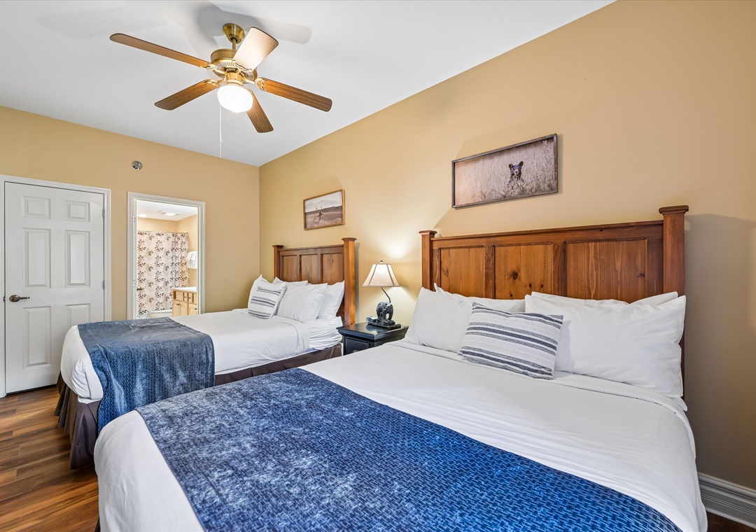 Relax in your cozy bedroom featuring two comfortable beds with crisp linens and rustic wood headboards under gentle ceiling fan breezes.