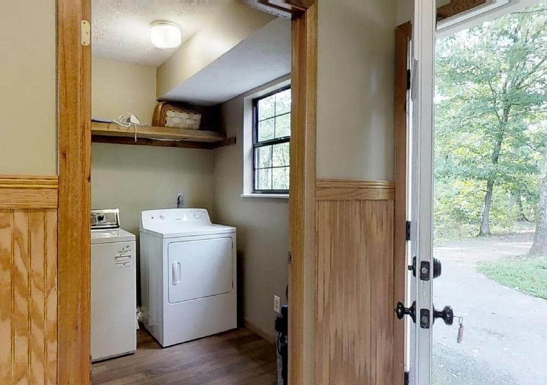 Step into your private laundry space with a washer and dryer, natural light from the window, and convenient access to the outdoors.
