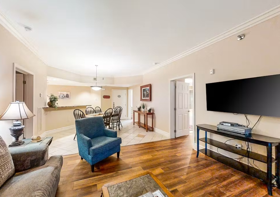 Unwind in your spacious living area with warm hardwood floors, cozy seating, and entertainment center—perfect for relaxing evenings after exploring the area.