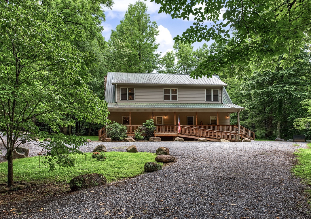Nestled in a lush forested setting, this spacious mountain retreat features a welcoming wraparound porch and ample parking, offering a peaceful escape surrounded by nature.