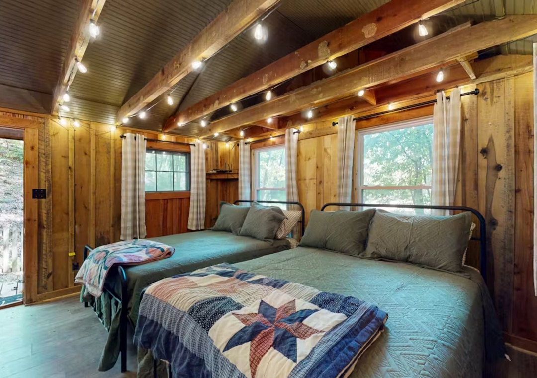 Drift off peacefully in your cozy cabin bedroom, where rustic wooden beams and twinkling string lights create the perfect forest retreat atmosphere.