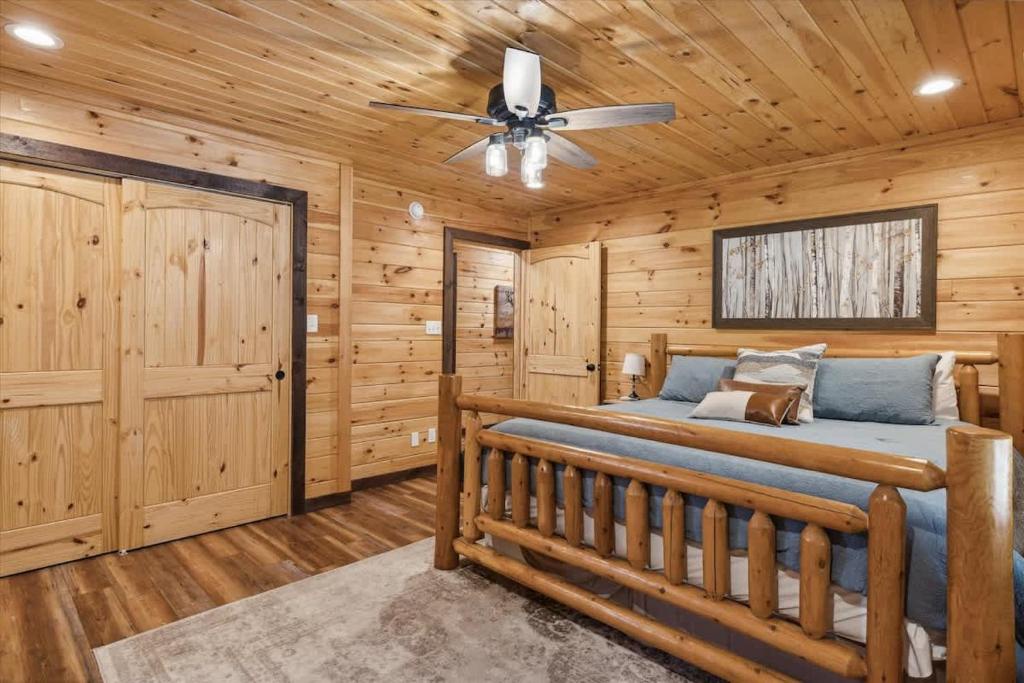 Step into your rustic retreat where warm wood surrounds you at every turn. Your handcrafted log bed awaits under a gently spinning ceiling fan, promising peaceful nights in this cozy mountain-inspired haven.