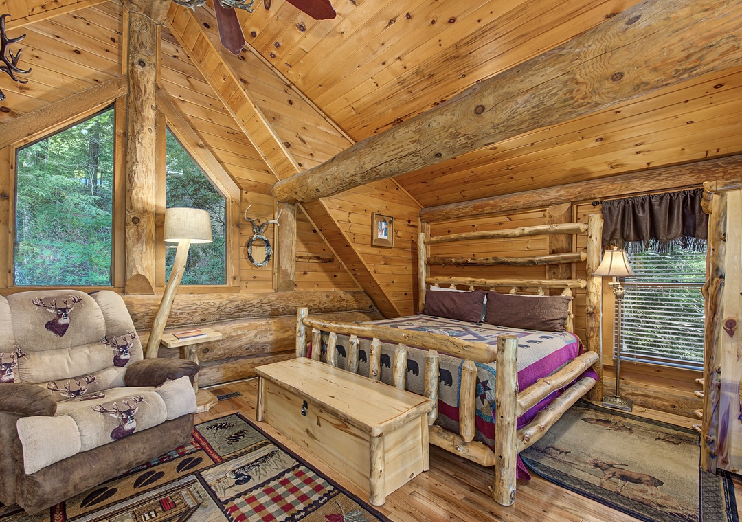 Cozy cabin retreat with rustic log beams, vaulted ceilings, and forest views. Handcrafted log bed and plush seating create the perfect retreat after mountain adventures.