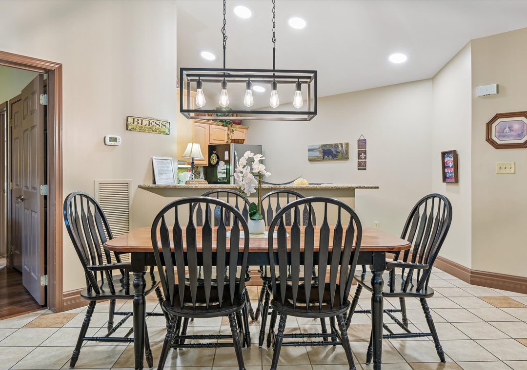 Gather around this welcoming dining table where memorable meals and conversations unfold under warm pendant lighting in your home away from home.