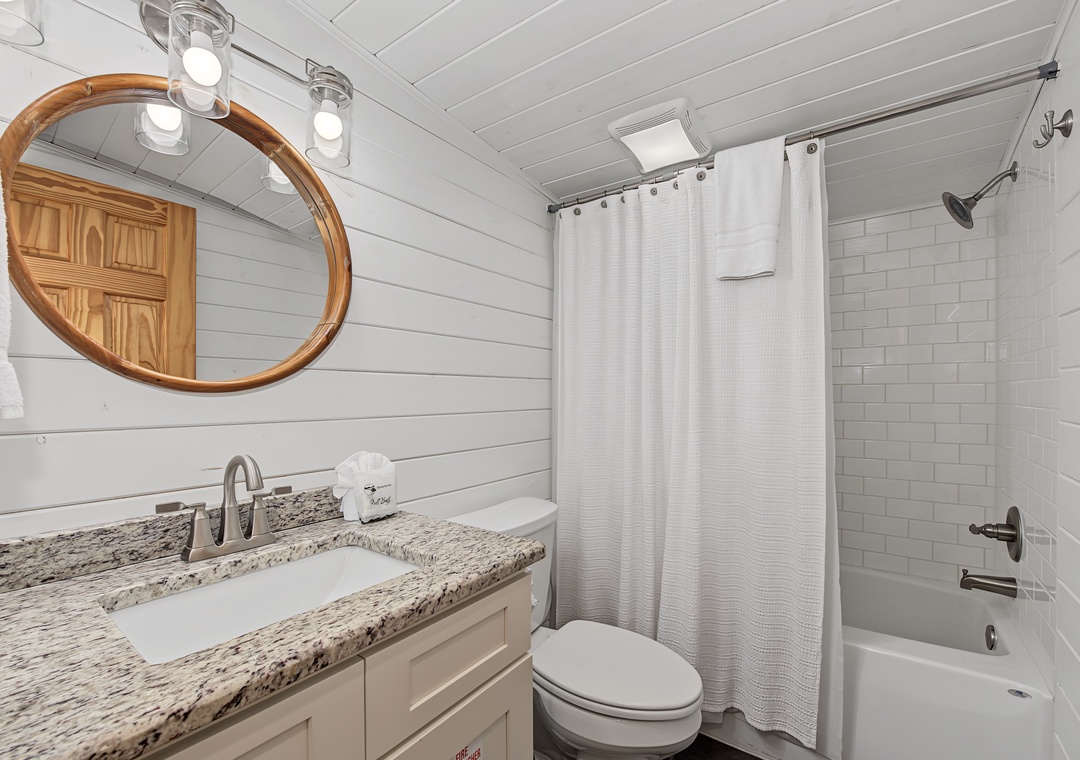 Step into your bright, refreshing bathroom with pristine white subway tiles, a spacious vanity, and a soothing shower-tub combo—perfect for unwinding after a day of adventure.