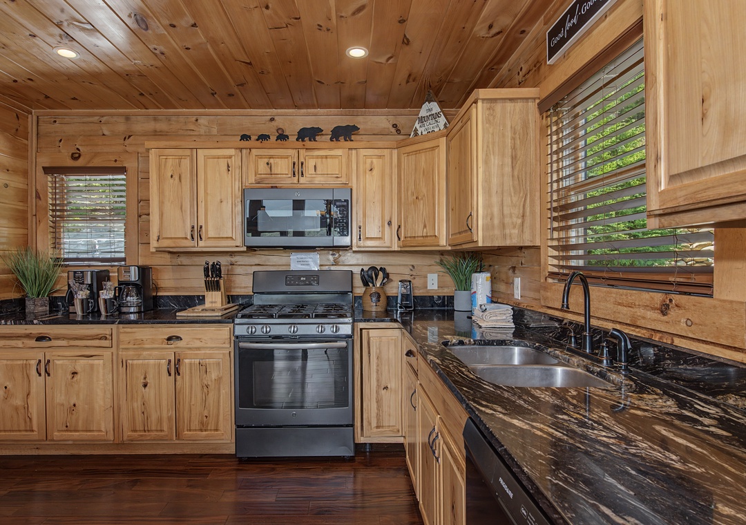 Your fully equipped kitchen awaits with rustic wood cabinetry, granite countertops, and modern stainless appliances—perfect for preparing family meals in cabin-style warmth.