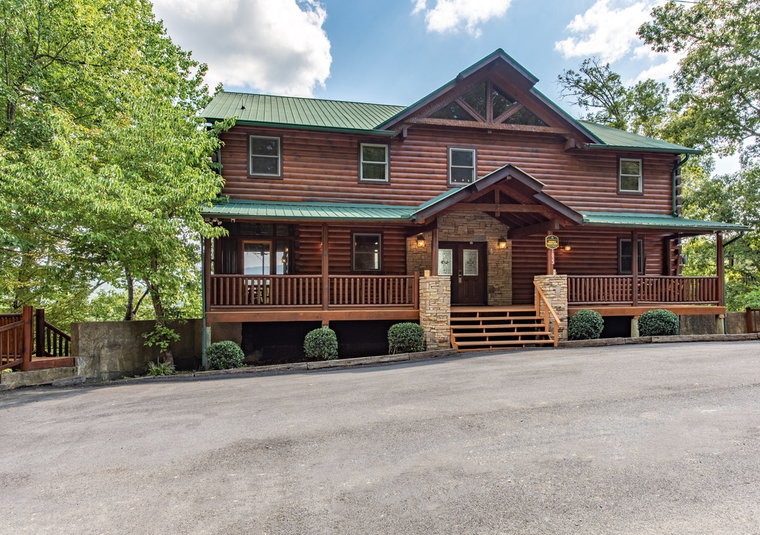 A spacious log cabin retreat with inviting covered porches and timber beam entrance, nestled among mature trees and offering convenient parking in a private mountain setting.