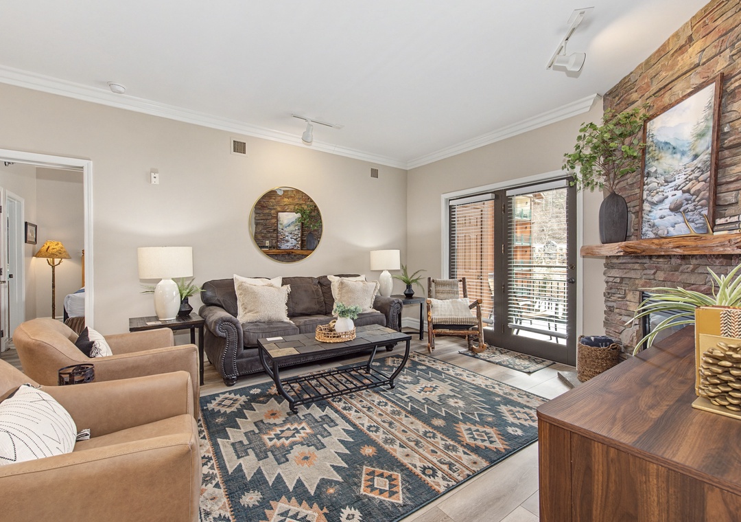 Cozy living room with stone fireplace where you'll unwind after exploring, complete with plush seating and natural light.