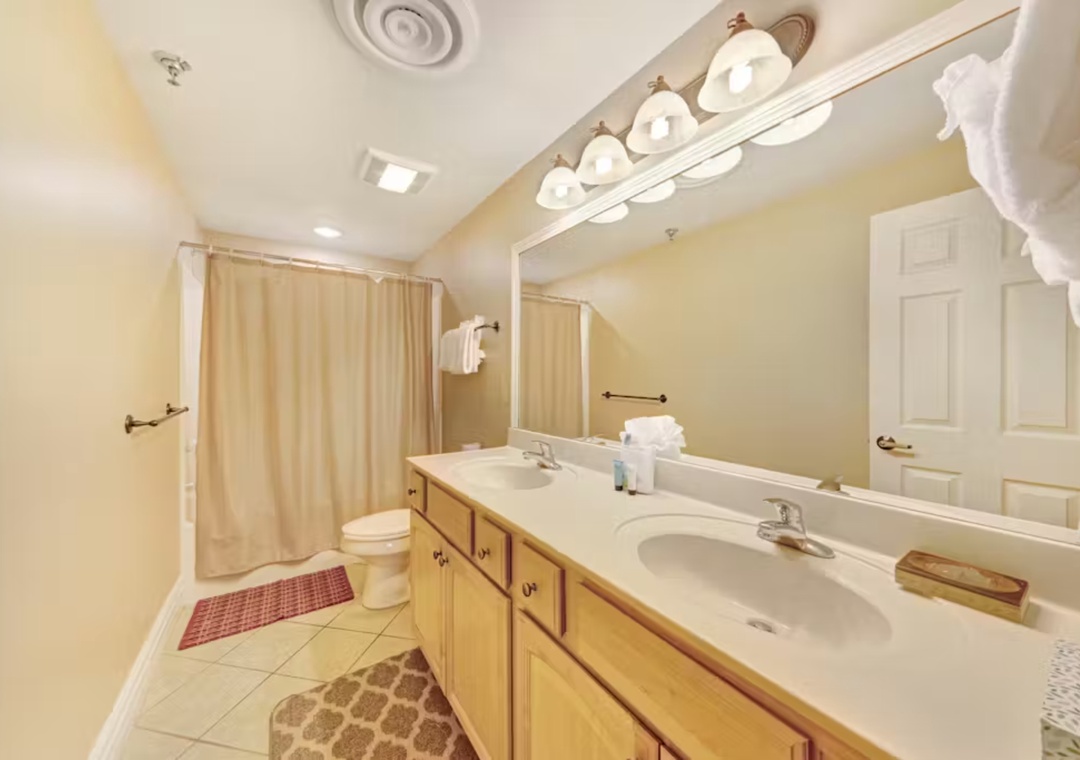 Your spacious bathroom features dual sinks, bright vanity lighting, and fresh towels awaiting your arrival.