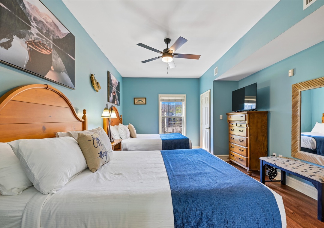 Drift off in your coastal-inspired bedroom with twin beds, soothing blue accents, and gentle ceiling fan creating the perfect ocean breeze.