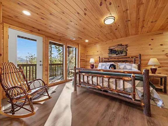 Step into your rustic mountain retreat where natural wood surrounds you. Relax in the rocking chair, rest in the handcrafted log bed, and wake to stunning mountain views through glass doors opening to your private balcony.