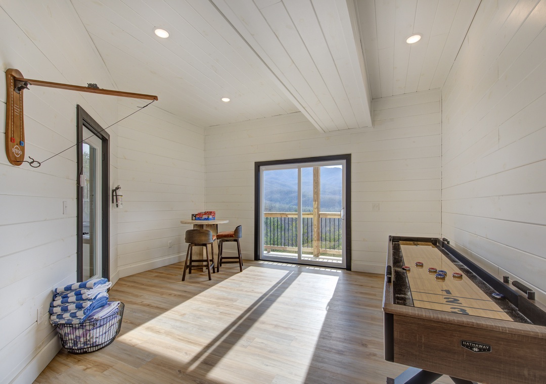 Challenge friends to shuffleboard while soaking up stunning mountain views through floor-to-ceiling windows in this bright game room.