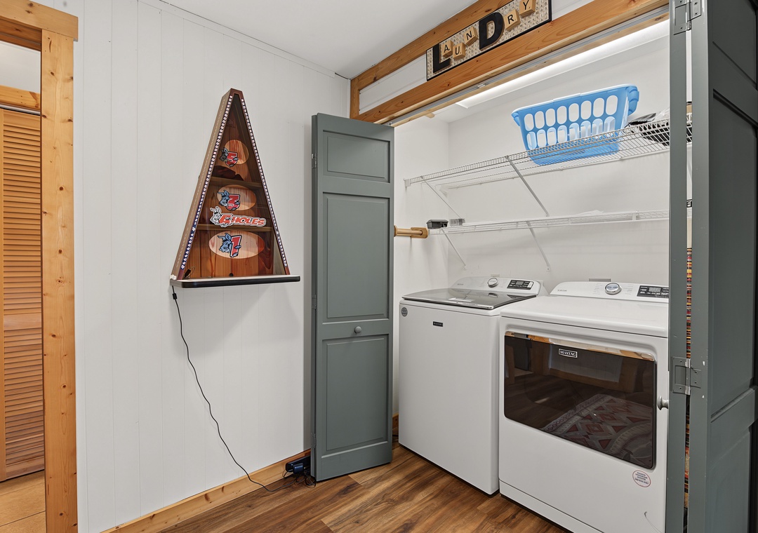 Your in-unit laundry area makes staying fresh effortless, with a washer and dryer tucked into a tidy space beneath warm wood-beam accents.