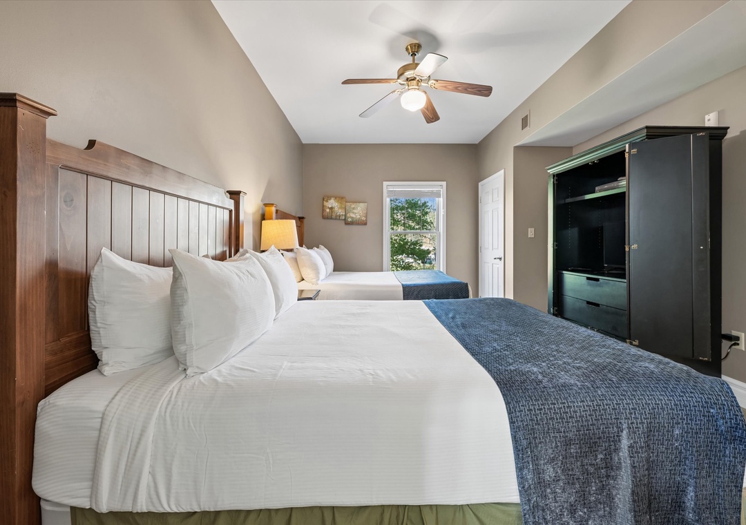 Sink into plush white linens and let the gentle ceiling fan create your perfect sleep sanctuary with warm wood accents.
