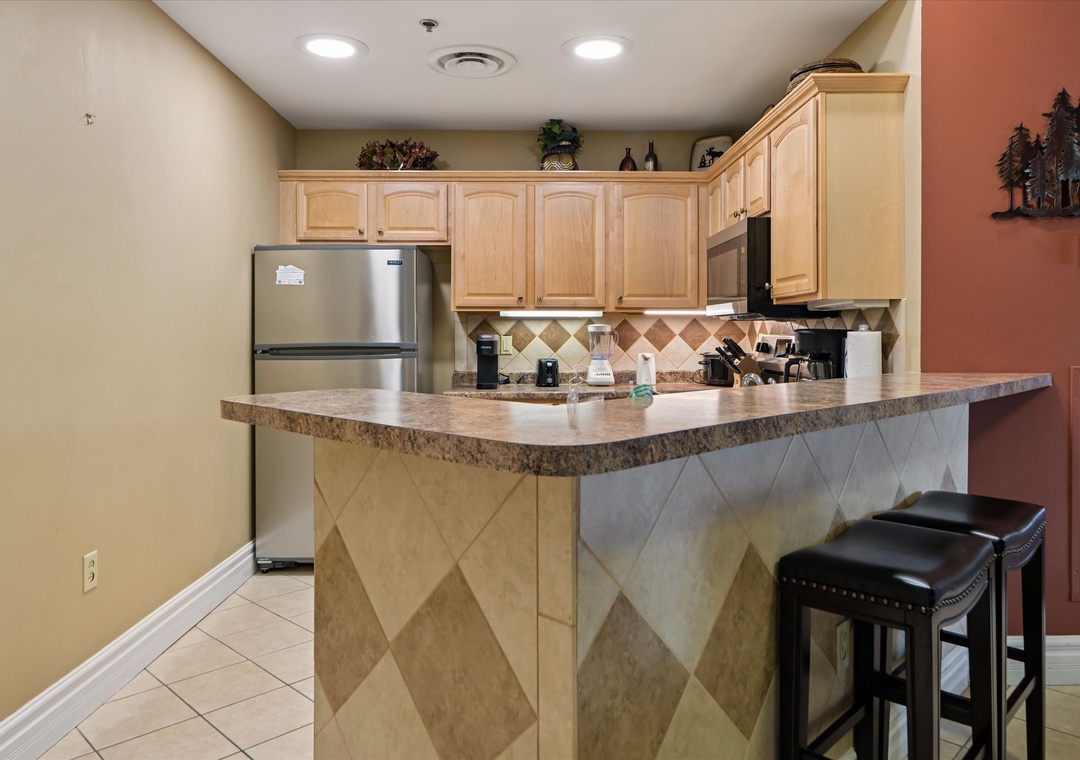 Your fully equipped kitchen awaits with granite countertops, stainless appliances, and a breakfast bar perfect for morning coffee.