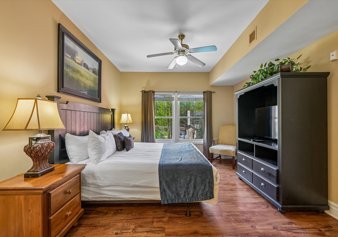 Rest peacefully in your cozy bedroom featuring a plush king bed, warm lighting, and entertainment center for ultimate relaxation.