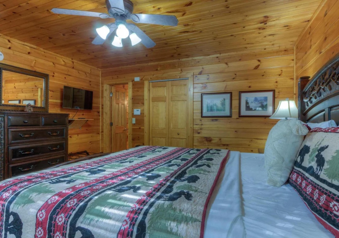 Drift off in your rustic pine sanctuary with soft lighting overhead and wilderness-inspired accents inviting peaceful mountain dreams after an adventure-filled day.