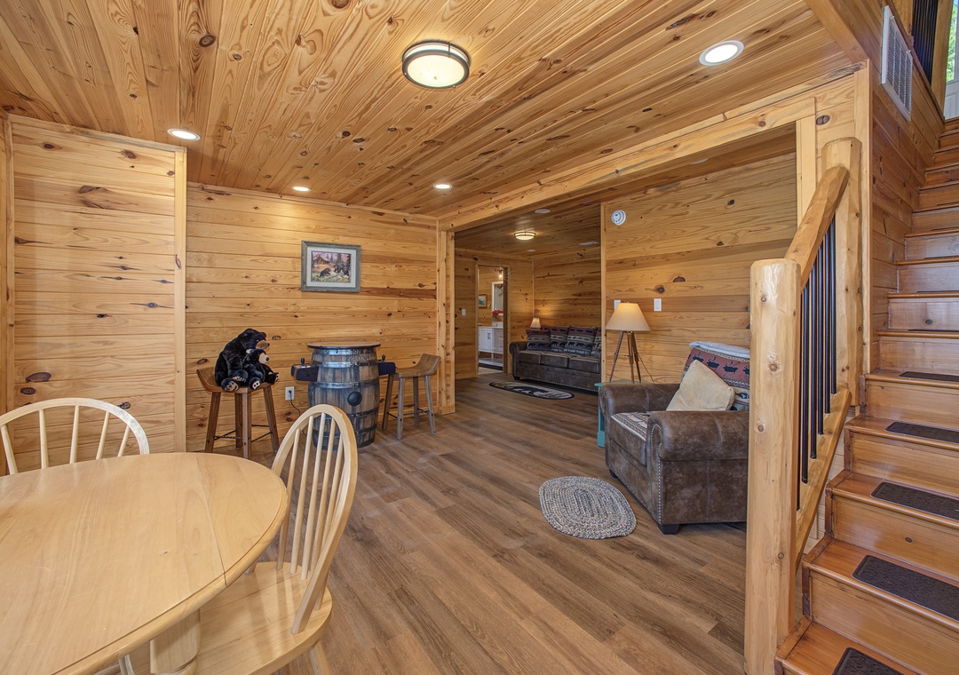 Warm wood surrounds you throughout this inviting open-plan cabin retreat, where rustic bar seating and cozy leather chairs await your downtime.