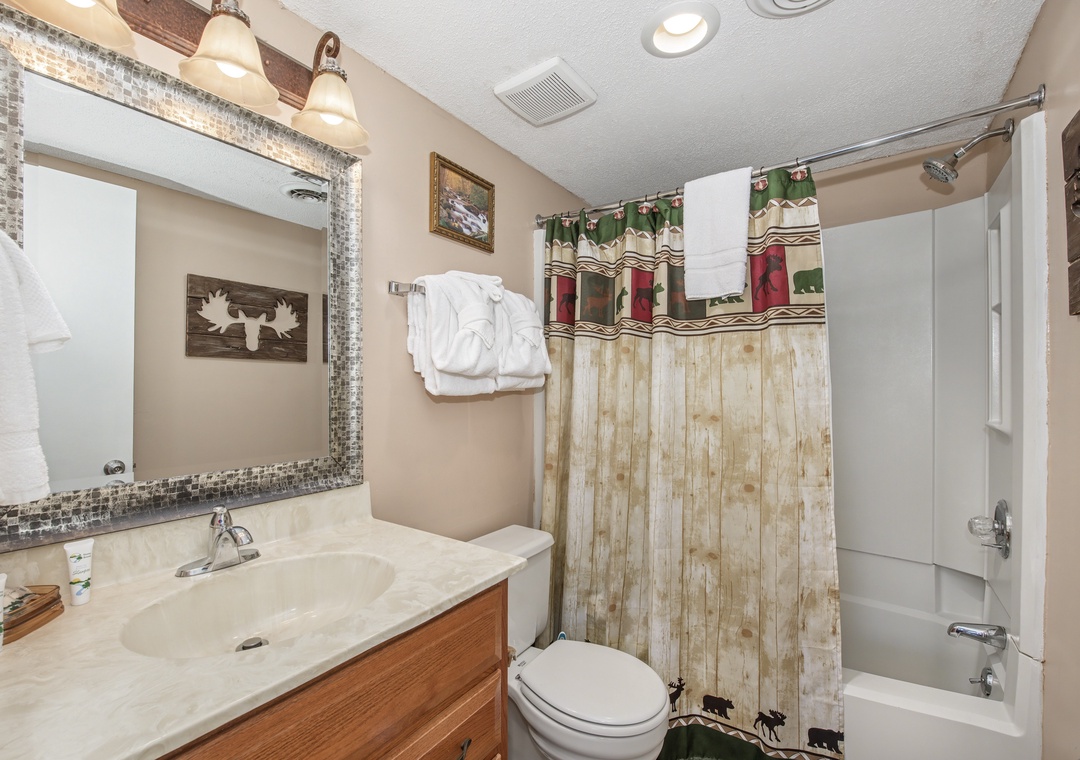 Your rustic bathroom features woodland charm with moose artwork and cozy cabin details for a relaxing mountain retreat experience.