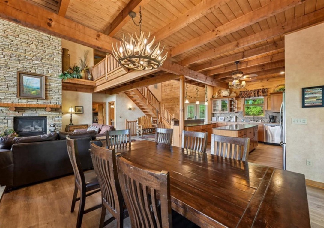 Picture yourself in this stunning open-concept cabin where rustic charm meets comfort. Vaulted wood ceilings, a grand antler chandelier, and a stone fireplace create a warm, inviting atmosphere perfect for your mountain getaway.