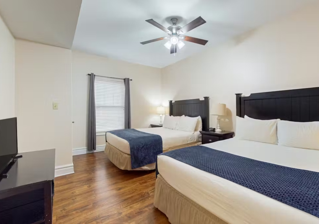 Two comfortable beds await you in this bright room with gleaming hardwood floors and a ceiling fan for perfect temperature control.
