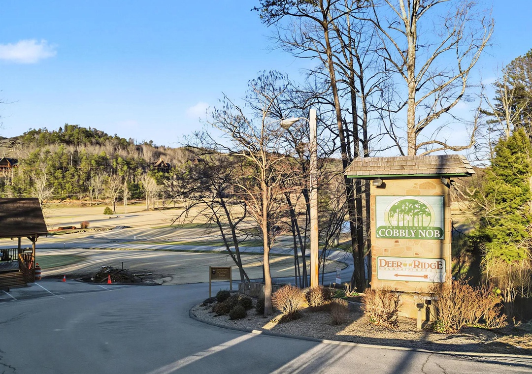 Property entrance marker at Cobbly Nob and Deer Ridge, situated in a scenic mountain setting with natural landscaping and forested hillsides.