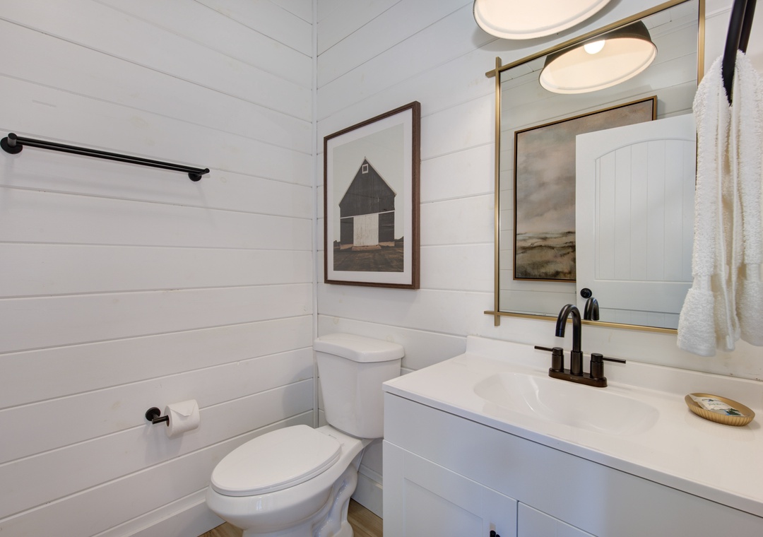 Refresh in your crisp, modern bathroom featuring clean lines, warm brass accents, and thoughtful artwork that creates a spa-like retreat.